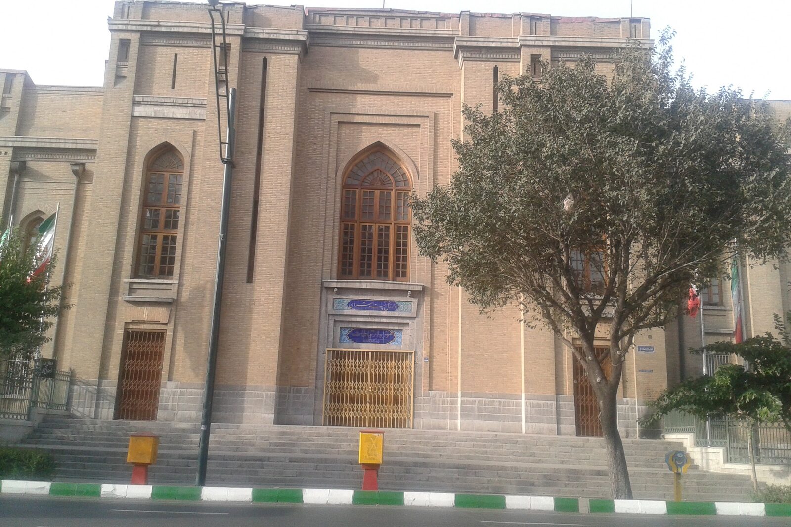 ساختمان آجری تاریخی ادارهٔ پست در ایران با کاشینوشتهٔ فارسی بالای در ورودی